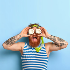 People, summer vacation, snorkeling and swimming concept. Funny bearded ginger man wears snorkel...