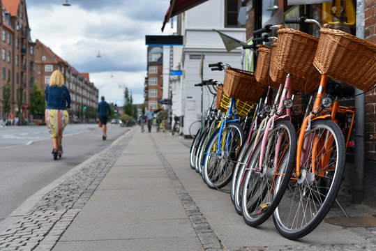 row of classic bicycles with baskets on street of Copenhagen