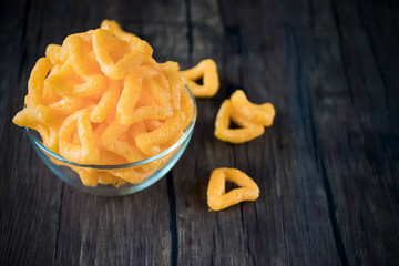 Crispy cornmeal snacks with cheese flavor in a brown bowl.