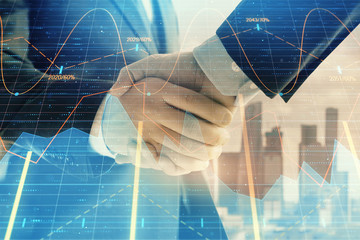 Double exposure of financial graph on cityscape background with two businessman handshake. Concept of stock market deal