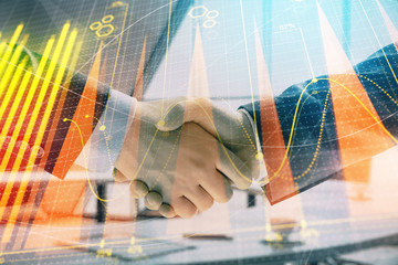 Multi exposure of financial graph on office background with two businessmen handshake. Concept of success in business