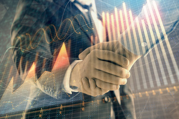 Multi exposure of forex graph on abstract background with two businessmen handshake. Concept of success on stock market