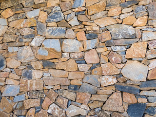 Old wall made of big and small stones . Vintage rough blocks surface background