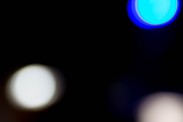 White and blue glare on black abstract background colored dust particles backlit from real flash multi-colored bokeh