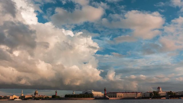 Light clouds stretched across the evening sky. Timelapse. Loop. 4K. Panarama sights of St. Petersburg. White night. View from the Neva river embankment.