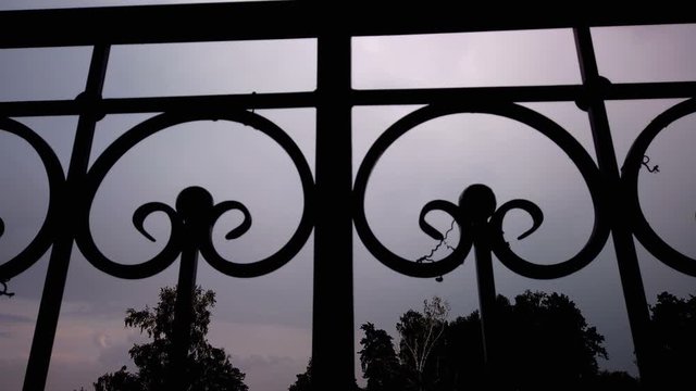Camera shoots from below wrought iron fence