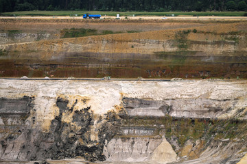 Erdschichten im Tagebau Inden im Rheinischen Braunkohlerevier und Straße mit Fahrzeugen - Stockfoto
