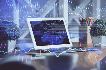 Financial chart drawing and table with computer on background. Double exposure. Concept of international markets.