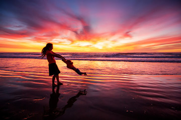Fototapeta premium mother and son having fun at sunset on the beach