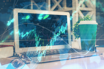 Financial market graph hologram and personal computer on background. Double exposure. Concept of forex.