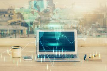 Double exposure of graph and financial info and work space with computer background. Concept of international online trading.