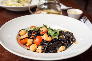 Pasta served in a white plate on a wooden table