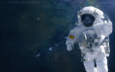 Fototapeta na wymiar Astronaut on background of cosmic landscape. Nebulae and star clusters of deep space. Science fiction. Elements of this image furnished by NASA