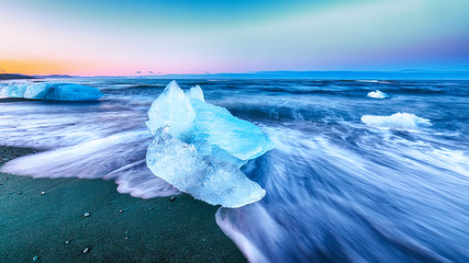 Incredible pieces of the iceberg sparkle on famous Diamond Beach at  Jokulsarlon lagoon during...