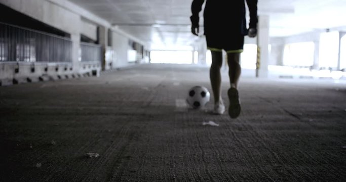 Teenager girl soccer player standing inside empty covered parking garage, putting spray paint can after drawing goals on the wall. 4K UHD 60 FPS RAW graded footage