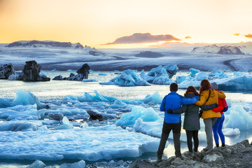 Group of tourist looking Beautifull landscape with floating icebergs in Jokulsarlon glacier lagoon at sunset - Powered by Adobe