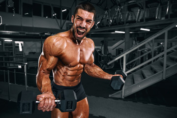 Fototapeta na wymiar Muscular Men Lifting Weights at the Gym