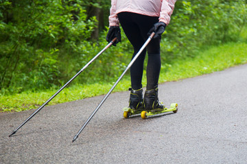 Woman cross-country skiing with roller ski in park