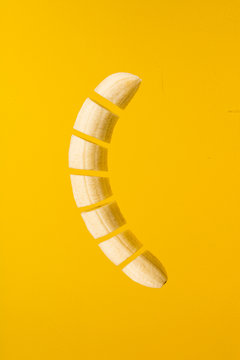 Cut banana on yellow background.