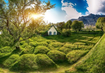 Picturesque view of  turf-top church Hofskirkja during sunset.