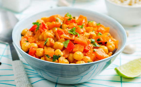 Chickpeas Carrots Pepper Coconut Milk Curry With Brown Rice On A Wood Background