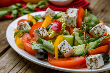 Greek salad with feta on wooden table
