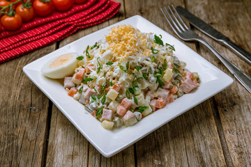 salad olivier on plate on wooden table