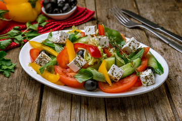 Greek salad with feta on wooden table