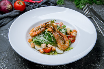 salad caesar with shrimps on grey concrete background