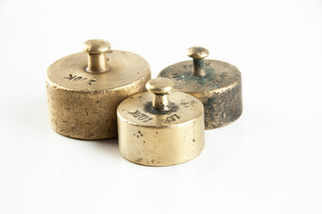 Antique bronze weights for scales on white background.