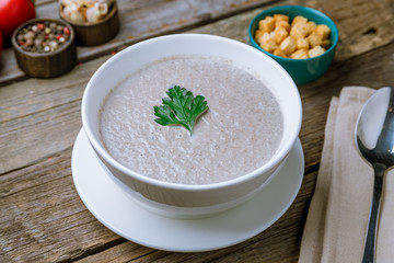 Cream soup of mushrooms on old wooden table