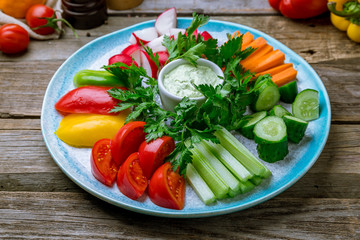 slicing fresh vegetables on a plate on wooden table