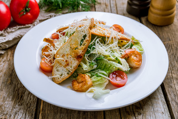 salad caesar with shrimps on wooden table