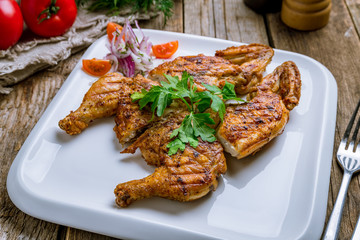 fried chicken tobacco on white plate on wooden table