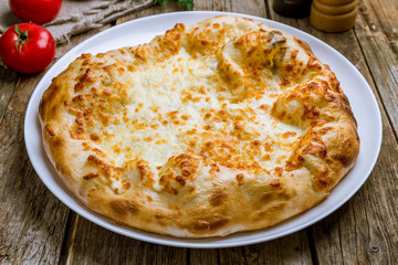 khachapuri with cheese on wooden table