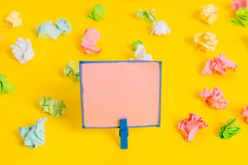 Colored crumpled papers empty reminder white floor background clothespin