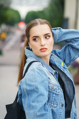 Beautiful model in denim jacket fashionable clothes in the city park.