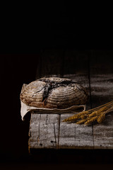 Beautiful fresh bread on wooden rustic background. Dark photography.
