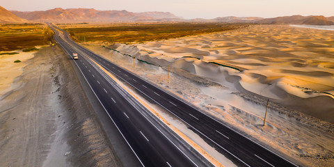Sand dunes of the peruvian desert at side of the Panamericana international road way. The panoramic...