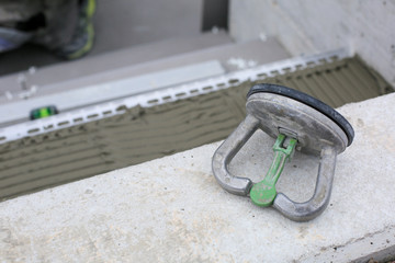 Tiler hands working on a new house entrance, local and professional handyman applying tiles to the steps.