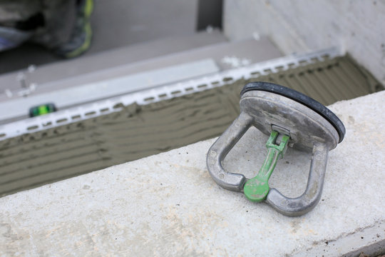 Tiler hands working on a new house entrance, local and professional handyman applying tiles to the steps.