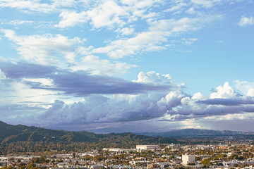 panaramic view of city businesses and homes with hillside homes and mountains