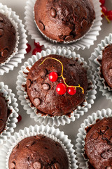 Chocolate muffins in cupcake paper forms, served with red currant. Top view