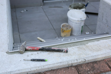 Tiler hands working on a new house entrance, local and professional handyman applying tiles to the steps.