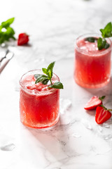 Fresh strawberry cocktail. Fresh summer cocktail with strawberry and ice cubes. Stawberry lemonade with leaves of mint.