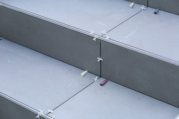 Tiler hands working on a new house entrance, local and professional handyman applying tiles to the steps.