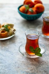Different oriental sweets on glass plate and turkish tea cups. Baklava,halva,apricots.