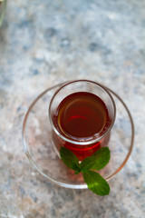 Turkish tea in traditional glass wit leaves of mint. Top view