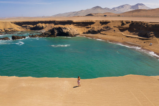 Aerial view of woman taking a view in a shore cliff in Huarmey, Ancash, Peru
