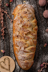 A fresh homemade loaf with chocolate, almond and powdered sugar. Loaf cake on wooden background.